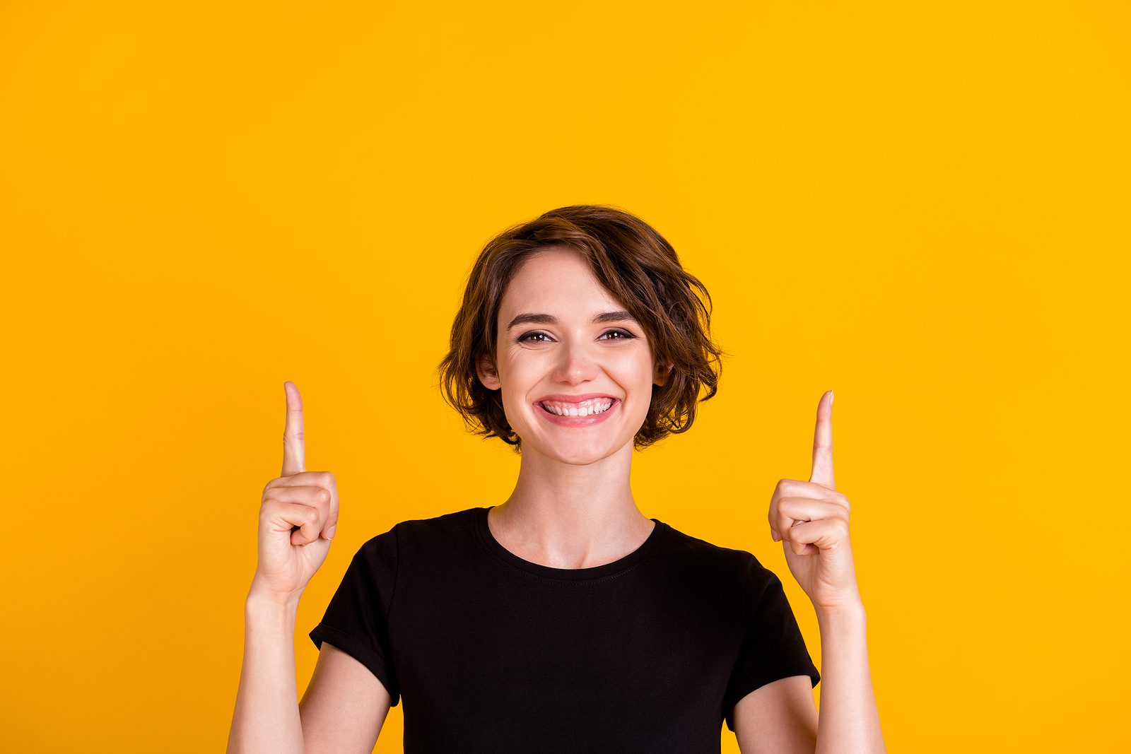 Close-up Portrait Of Lovely Glad Cheerful Girl Pointing Two Fore