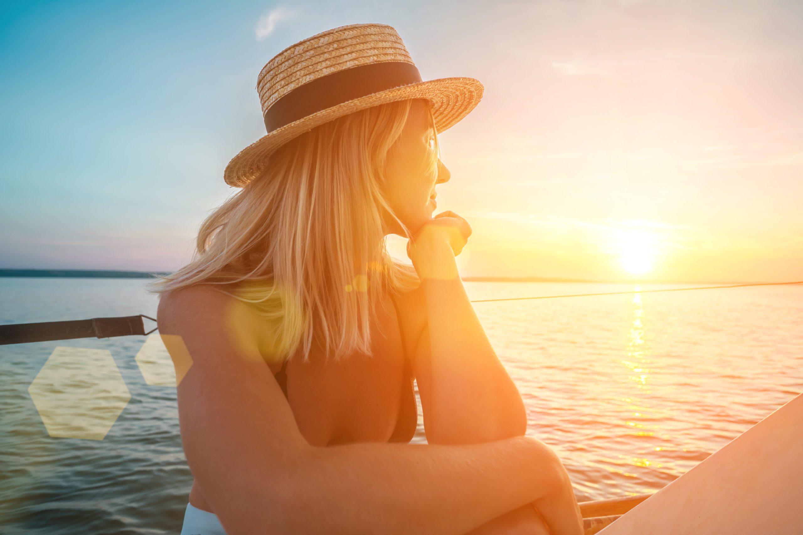 Young happy woman enjoying sunset from deck of sailing boat movi Woman thinking about her positive pregnancy test.
