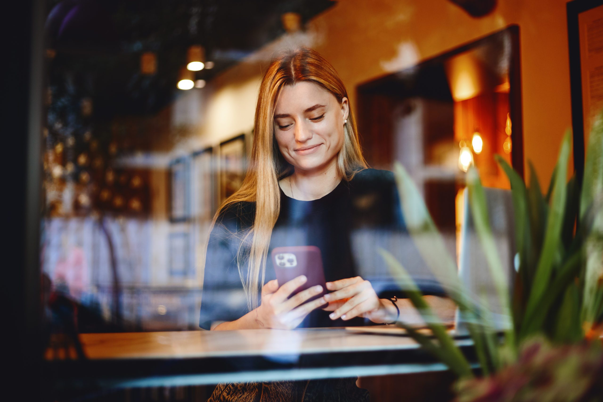 Pretty Blonde Woman Sitting At A Cafe Using Smartphone. Cute Gir