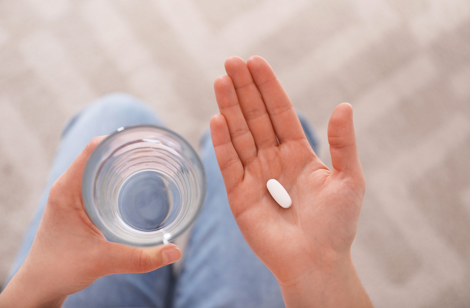 Young Woman With Abortion Pill And Glass Of Water, Top View